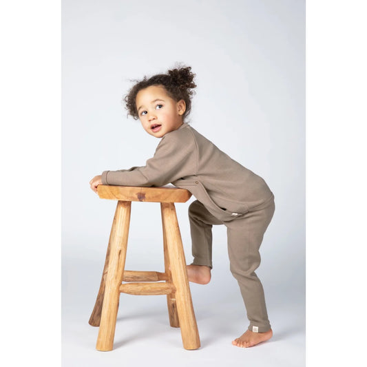 Baby in weichem sandfarbenem Wickelshirt mit Langarm und passender Hose