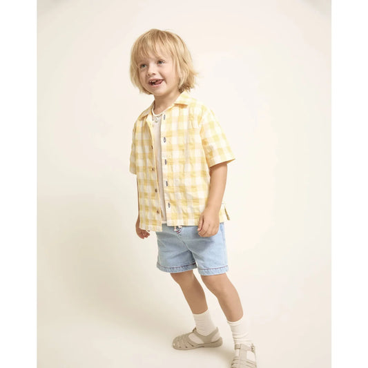 Fröhliches Mädchen in Denim Bermuda Hose hellblau Karo-Shirt