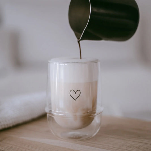 Doppelwandiges Glas Herz mit schwarzem Herz-Design, gefüllt mit Latte Macchiato