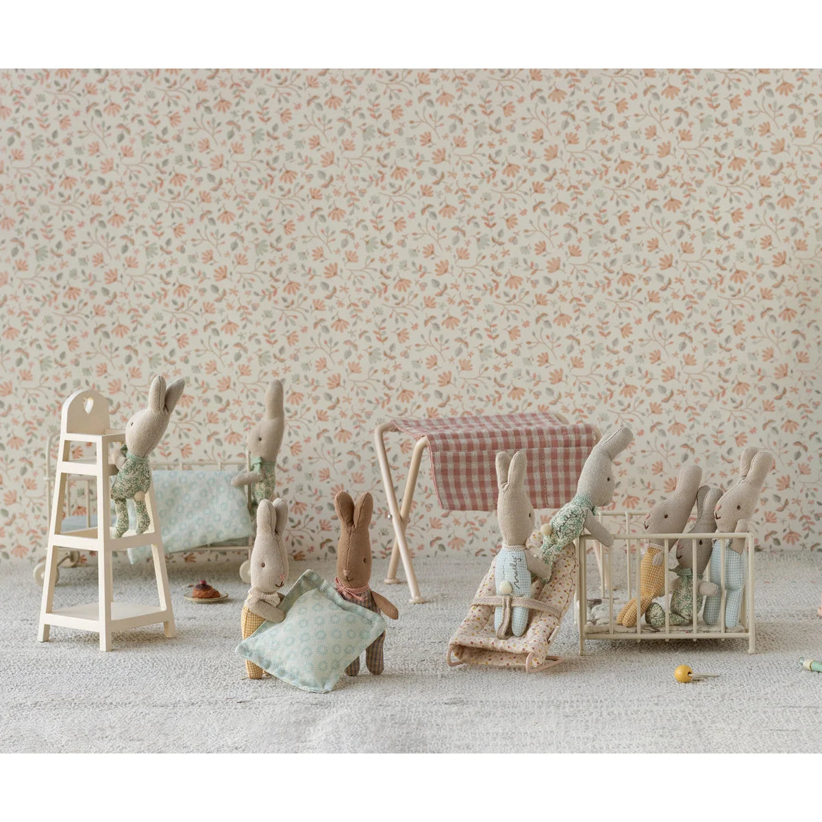 Kollektion von Plüschhasen mit Miniaturmöbeln im Gitterbett-Design
