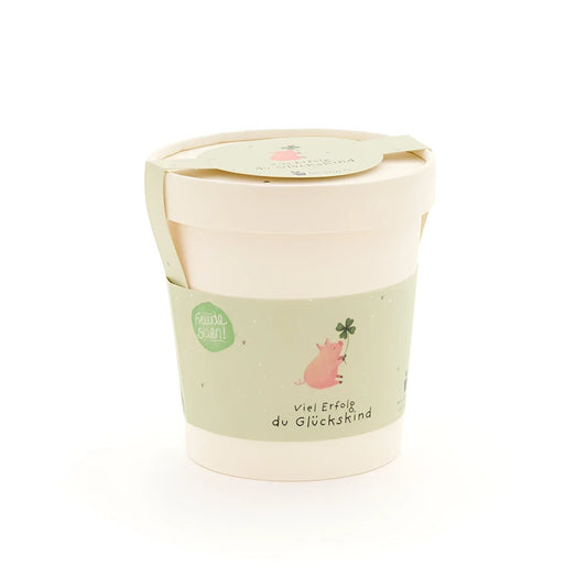 Glückskind becher aus pastellgrünem und cremefarbenem papier mit süßem rosa schwein und vierblättrigem klee