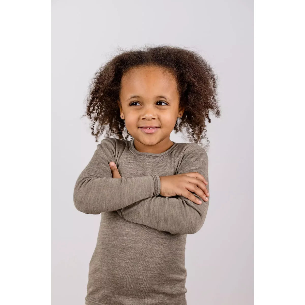 Kleines Kind in weichem grauem Langarmshirt mit gekreuzten Armen, Kinder Longsleeve Walnuss