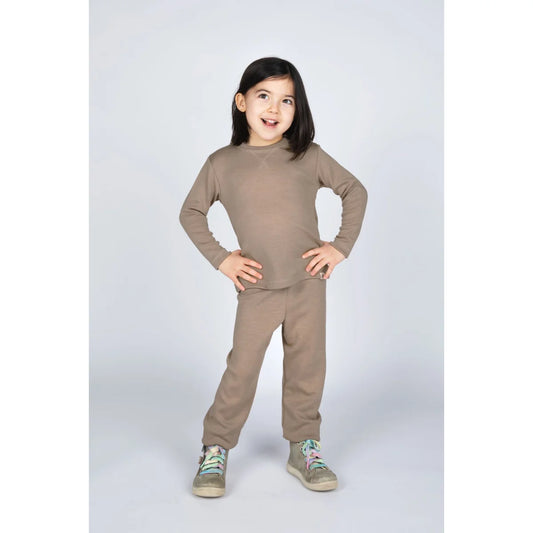 Junges Mädchen in sandfarbenem Kinder-Sweatshirt-Set mit Langarm-Top und Hose