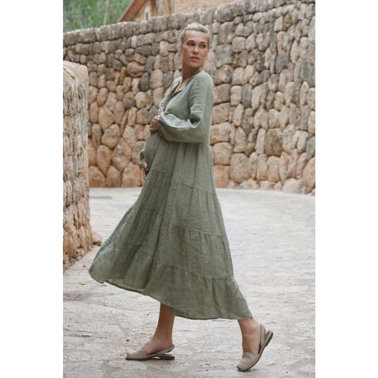 Ein fließendes olivegrünes stufenkleid aus leinen mit langen ärmeln ideal für nachhaltige babykleidung schweiz