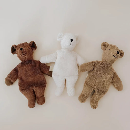 Drei plüschige Teddybären in verschiedenen Braun- und Weißtönen nebeneinander