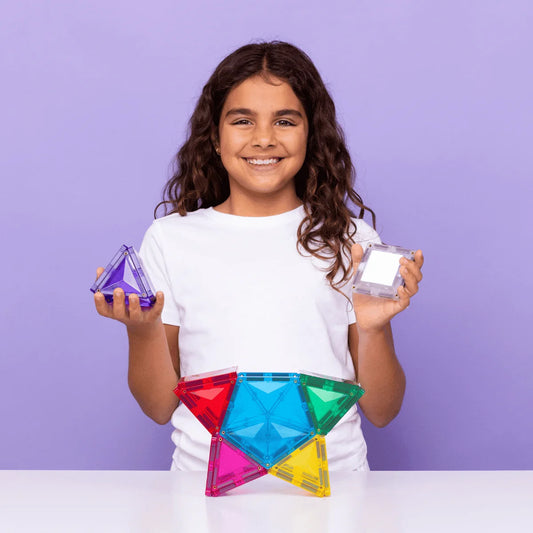Lächelndes Mädchen hält bunte Magnetbausteine Light Star Pack 28 Stück
