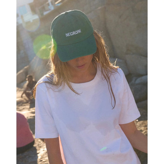 Dunkelgrüne negroni cap mit weißem sticklogo ideal als geschenk für neugeborene und ökologische kinderprodukte