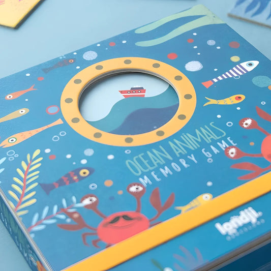 Blaues Kartonspiel Ocean Animals Memory mit gelbem Bullauge und bunten Meeresillustrationen von Londji