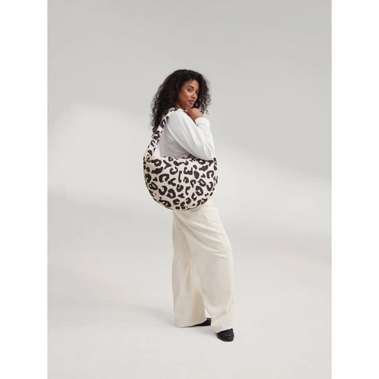 Puffy cross body bag mit weichem rundem design und schwarz-cremefarbenem leopardmuster ideal für ökologische