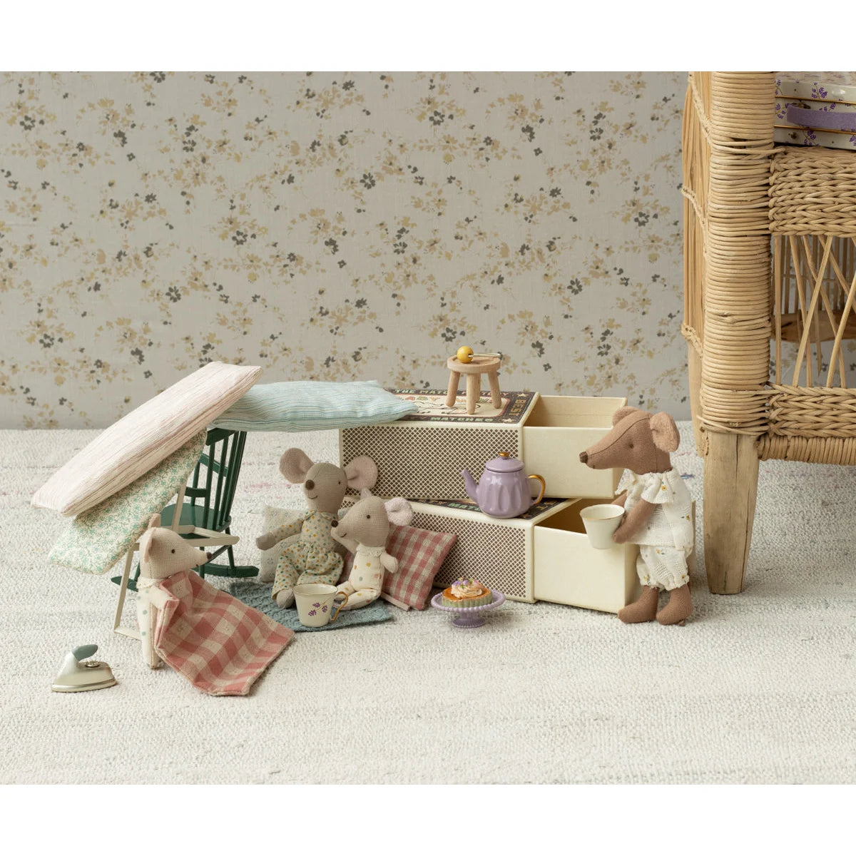 Ein dunkler grüner schaukelstuhl maus neben einer lavendelfarbenen teekanne mit golddeckel im dollhouse für ökologische