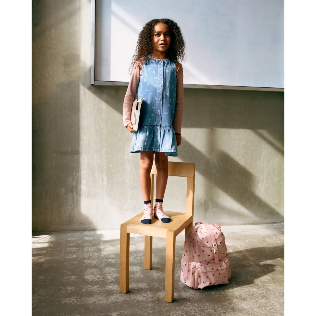 Rosa rucksack mit schwarzen punkten neben 5er-pack silas socken mood mix in verschiedenen farben