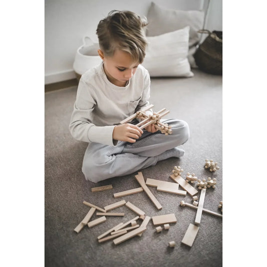 Kind trägt START 140 Spielset zusammen: Brixis, Twister, Timber Bricks