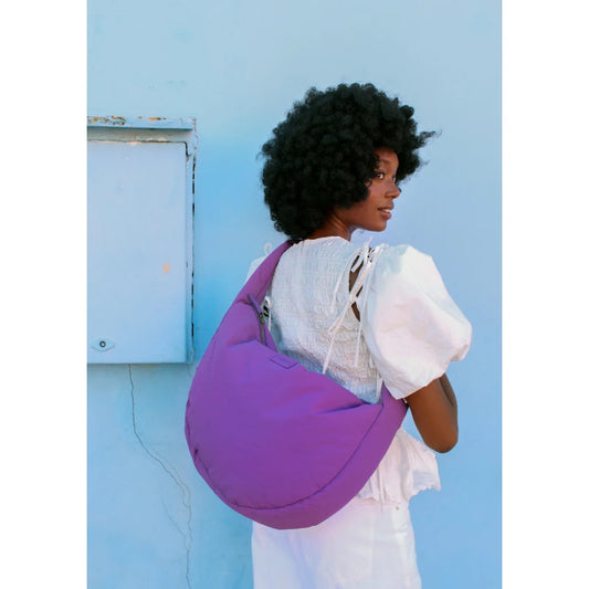 Texturierte puffy crossbody tasche aus lila stoff mit weicher, abgerundeter form und sichtbaren nähdetails