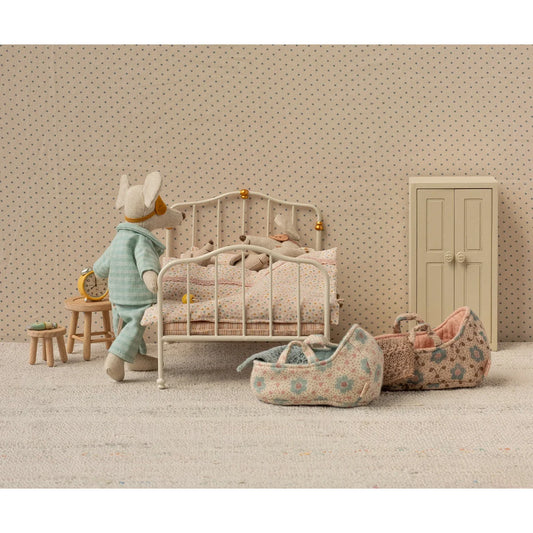 Weißes Metallbabybett mit Goldakzenten und gemustertem Bettzeug, Tragetasche Babymaus Blau