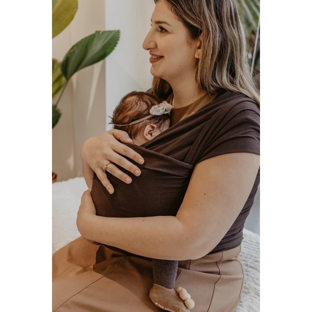Nahaufnahme des dunkelbraunen Tragetuchs Brownie von Little Wombat um Mutter und Baby gebunden