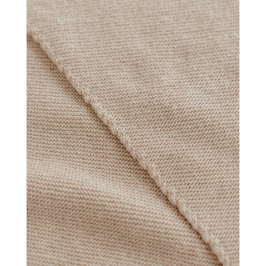 Nahaufnahme von hellbeigem, fein gestricktem Stoff beim Triangle Schal Josephina Sand