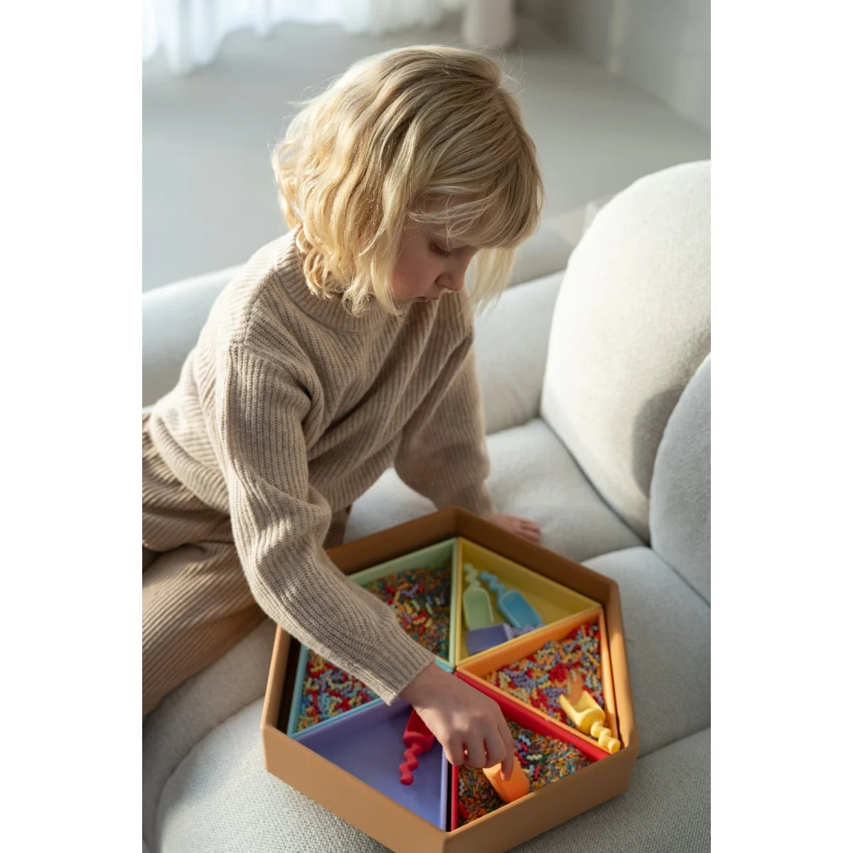 Wellen schaufel-set pastel ein sechseckiger holz-sinnesbehälter mit bunten fächern gefüllt mit konfetti und spielzeug