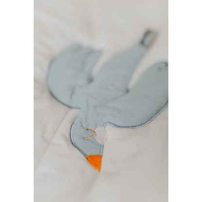 Ein soft hellblauer gestickter vogel-förmiger plüsch mit orangefarbenem schnabel auf einer activity decke für nachhaltige
