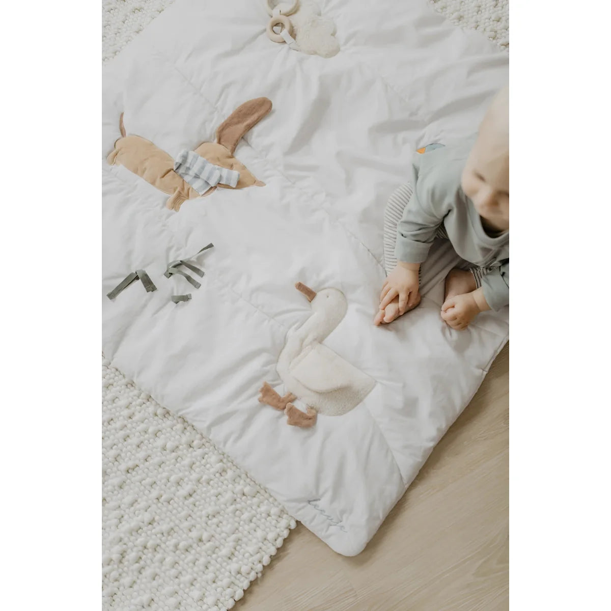 Weiße gesteppte activity decke mit bestickten plüschfiguren ente und hase in beige akzenten für ökologische