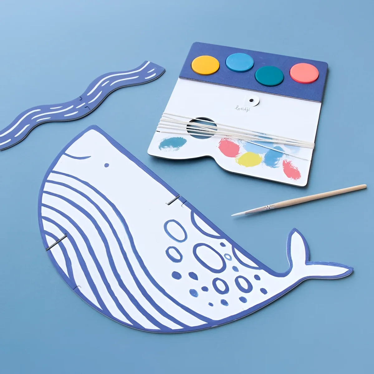 Weißes Papierwal mit blauen Wellenlinien und dekorativen Punkten für Al mare