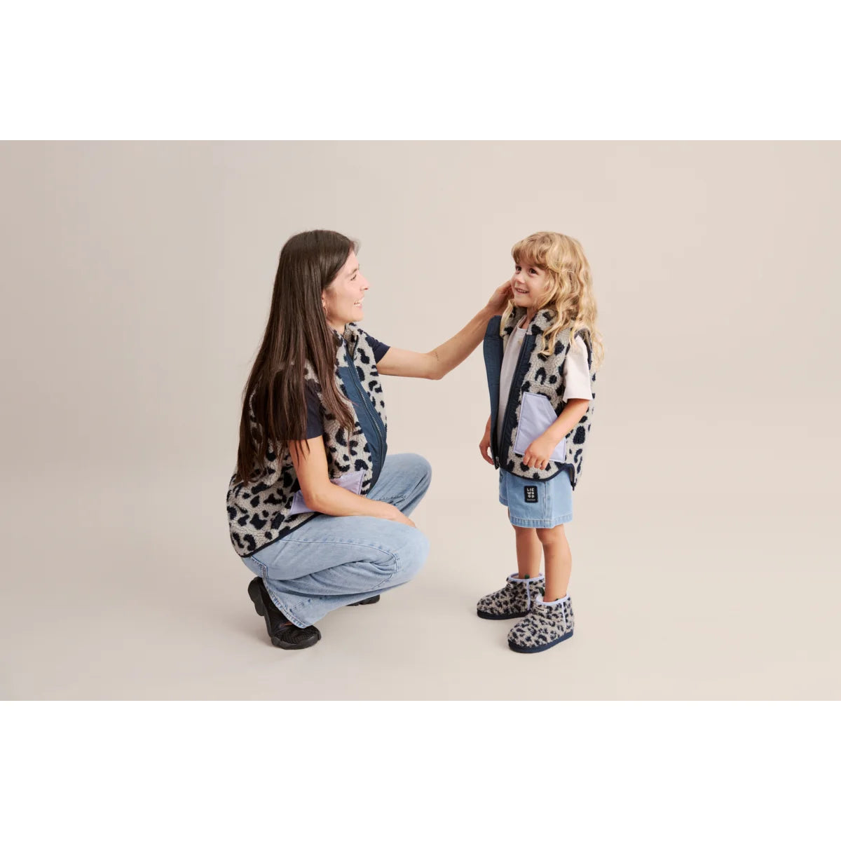 Ein kind trägt albi pile boot leo mist mit leopardmuster und passendem weste- und denim-shorts-look