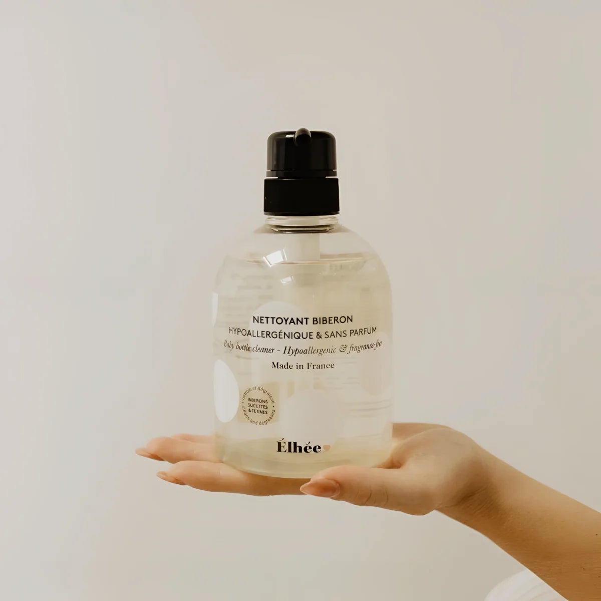 Klarer plastikflasche mit schwarzem pumpspender etikettiert nettoyant biberon von éllee babyflaschenreiniger