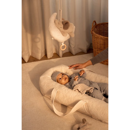 Baby in einem gemütlichen Nest aus GRO Fleece in Sandfarbe für Komfort und Sicherheit