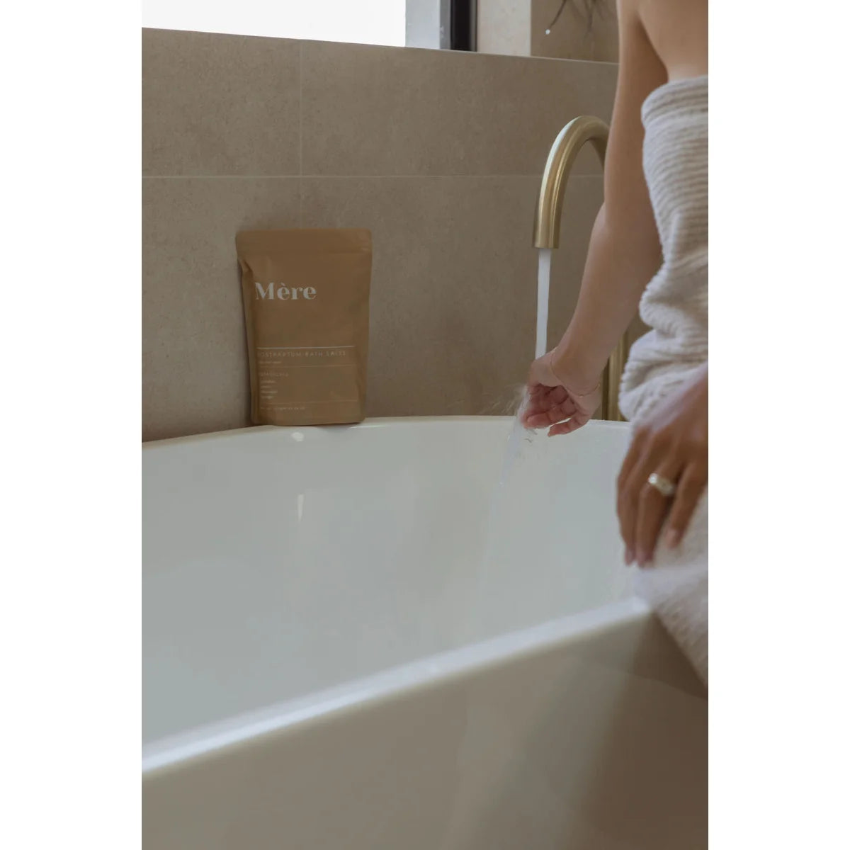 Badewanne mit braunem Papiersack Merci am Rand, Badesalz Postpartum dargestellt