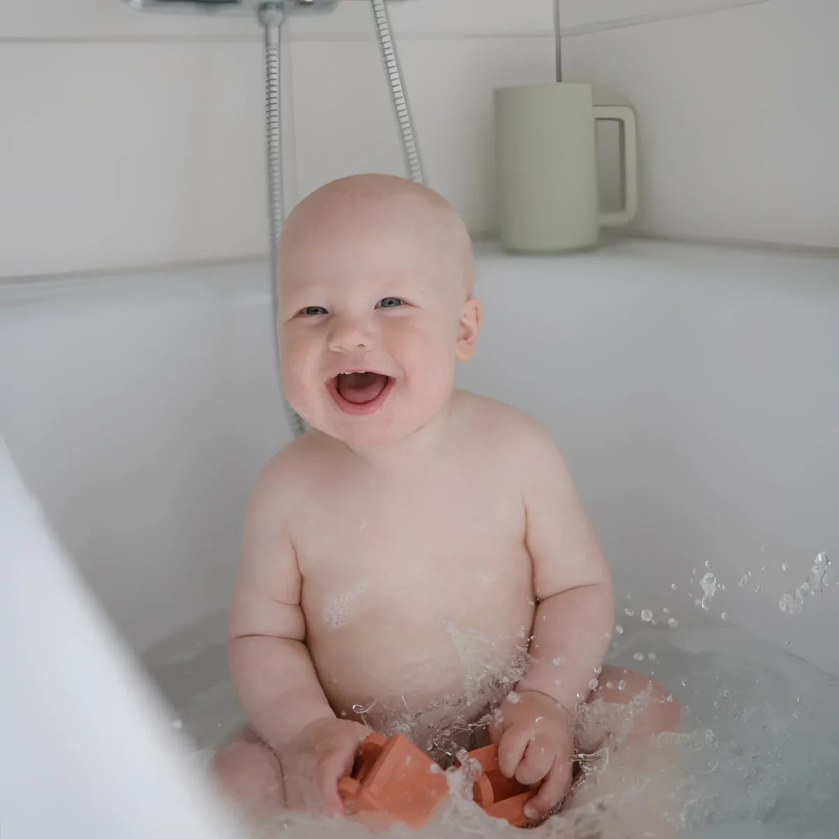 Lachendes Baby im Badewanne mit Wasser und Schaum, Badespielzeug Fahrzeuge 4 Set