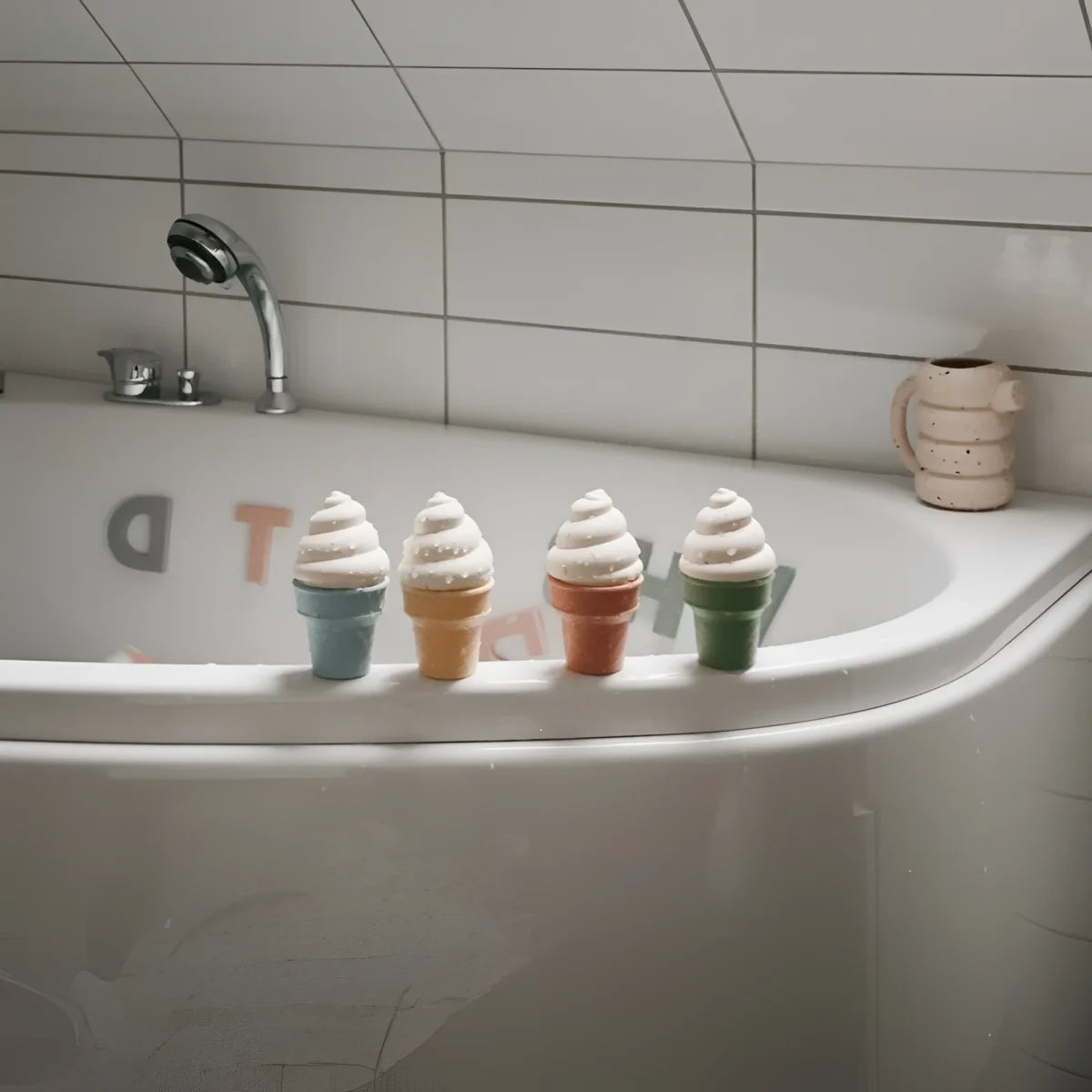 Badespielzeug match ice cream toy mit vier bunten keramik-eistütenbadspielzeugen mit weißen wirbeln und pastellfarbenen kegel