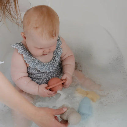 Weicher grau geblümter baby badeanzug mit gerüschten trägern und schimmelresistentem badespielzeug space