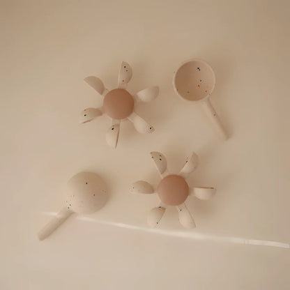 Creamfarbene keramiklöffel und blumenförmiges geschirr mit gesprenkelter textur für badespielzeug wasserrad