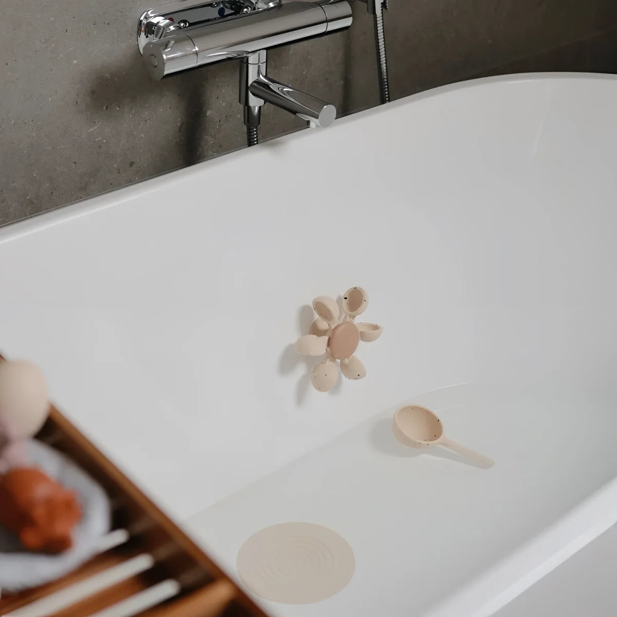 Beiges, blumenförmiges badespielzeug wasserrad mit zentraler runder basis und blütenblattförmigen armen