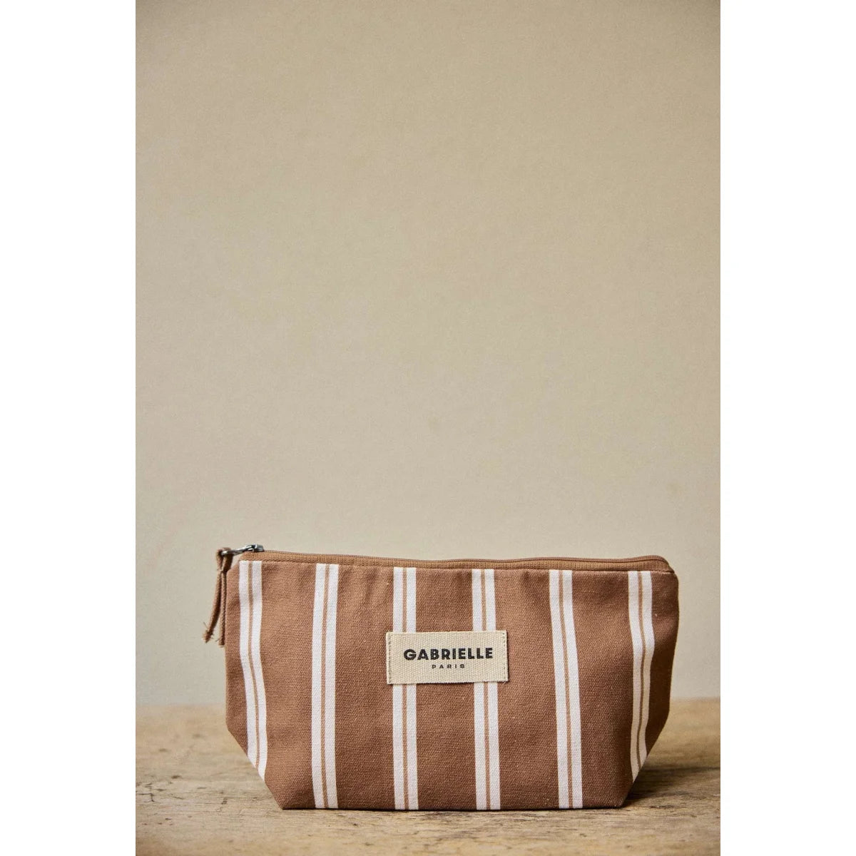 Beauty Pouch Noisette Stripes: braun-weisse Canvas-Makeup-Tasche mit beigem Etikett von Gabrielle Paris