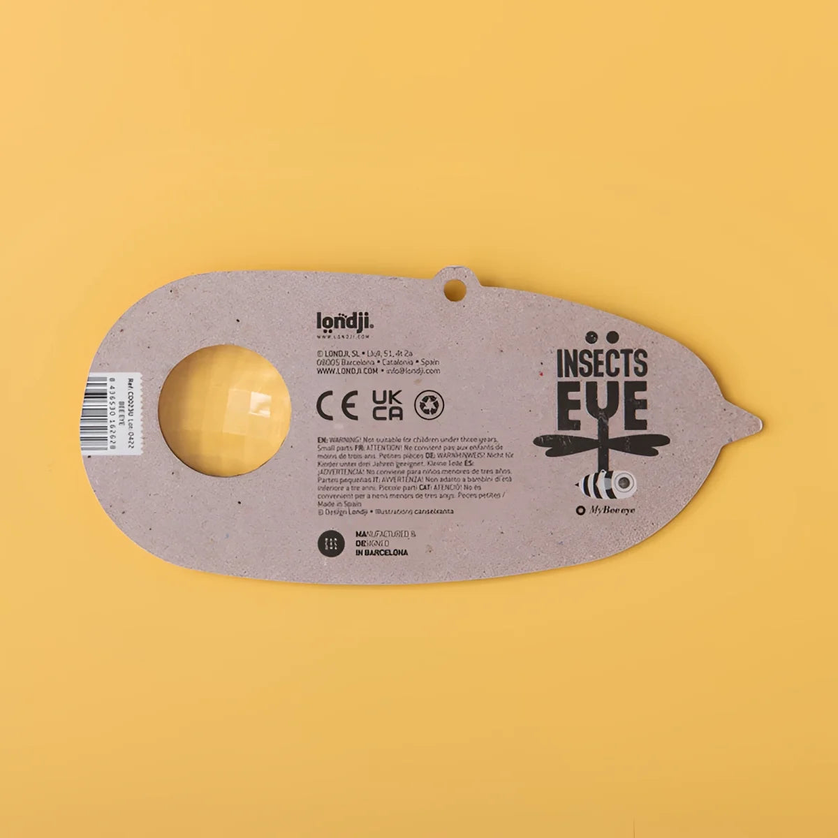 Graues Insekt-Auge-Spielzeug aus recyceltem Karton mit gelber Linse und Libellendesign