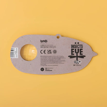 Graues Insekt-Auge-Spielzeug aus recyceltem Karton mit gelber Linse und Libellendesign