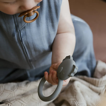 Grauer, elefantenförmiger Beißring Koala in der Hand eines Babys