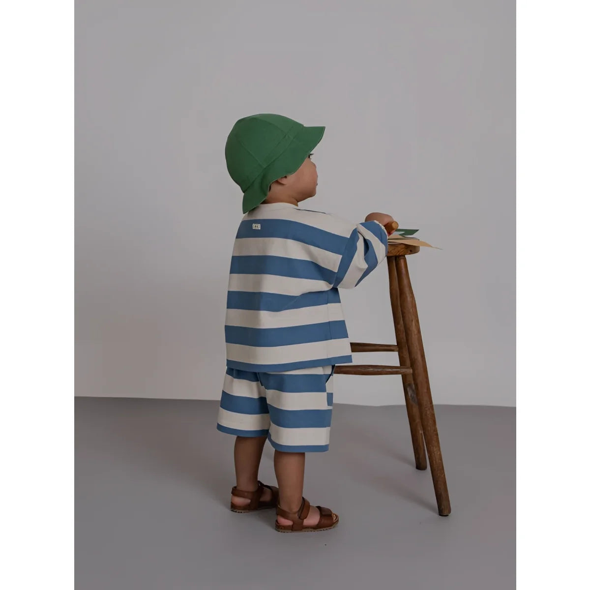 Eine frau und ein kind in passenden weißen outfits, das kind trägt bermudas mit deckchair-streifen in blau und weiß