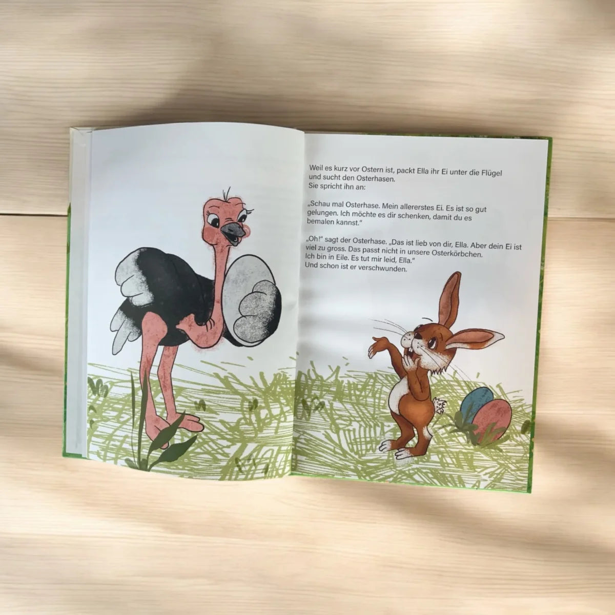 Offenes Kinderbuch mit bunten Cartoon-Illustrationen zum Thema Strausseneier
