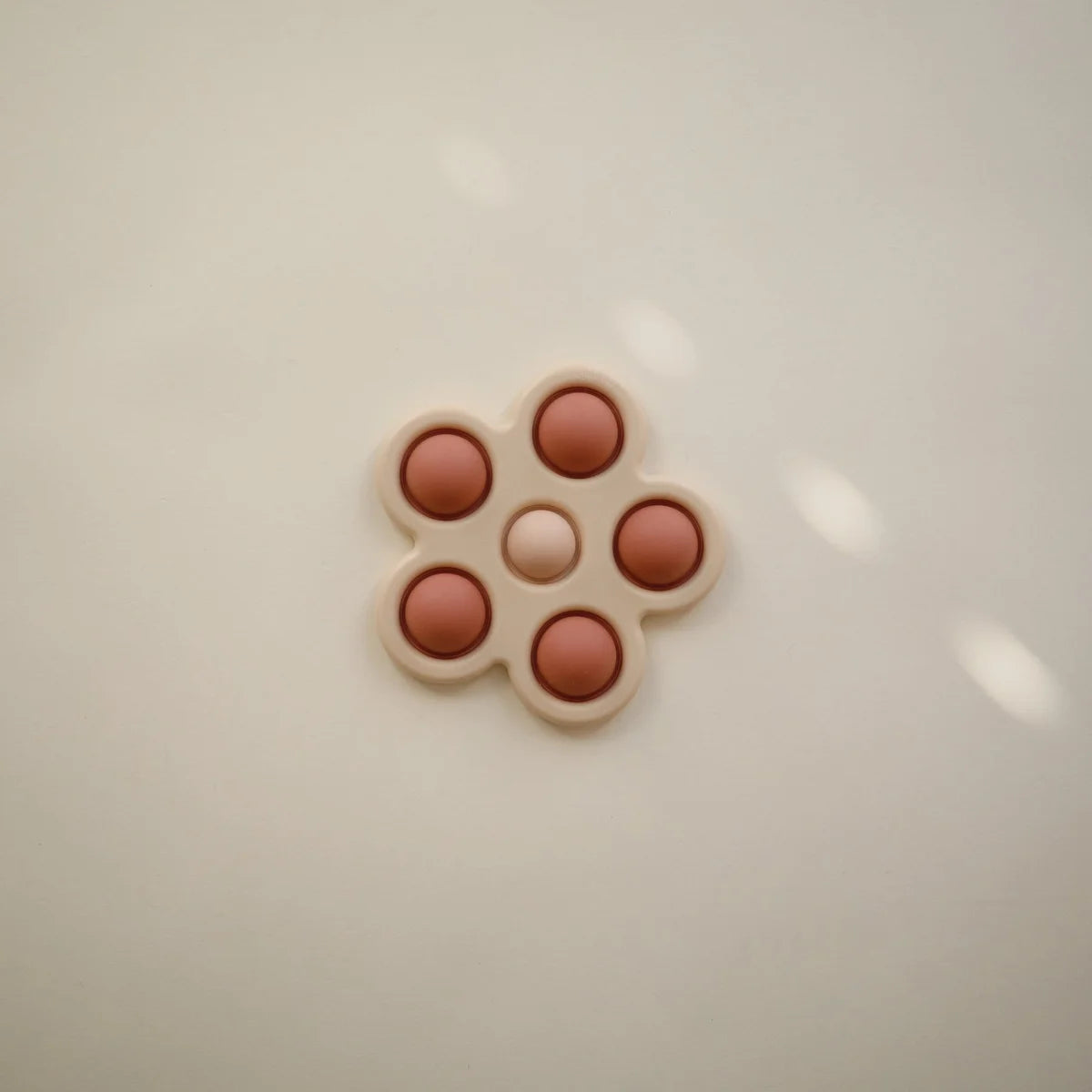 Blume Plop-it Spielzeug in Blush/Rose mit pillenförmiger Anordnung in blühender Form