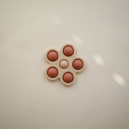 Blume Plop-it Spielzeug in Blush/Rose mit pillenförmiger Anordnung in blühender Form