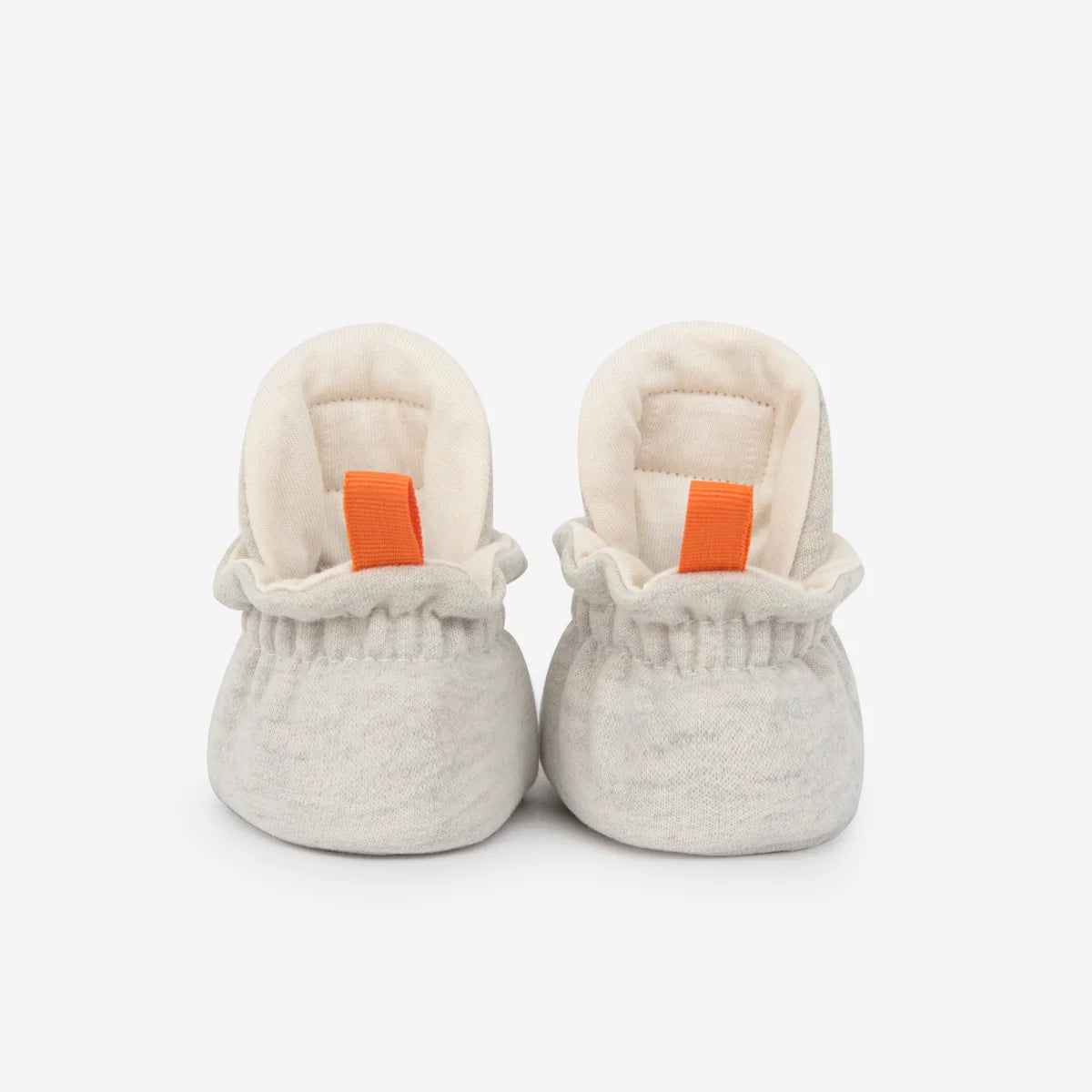 Weiche offwhite cotton gripper baby booties mit gerüschtem bund und orangefarbenen ziehhilfen für nachhaltige babykleidung