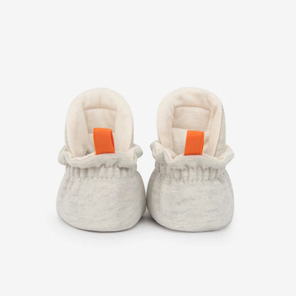 Weiche offwhite cotton gripper baby booties mit gerüschtem bund und orangefarbenen ziehhilfen für nachhaltige babykleidung