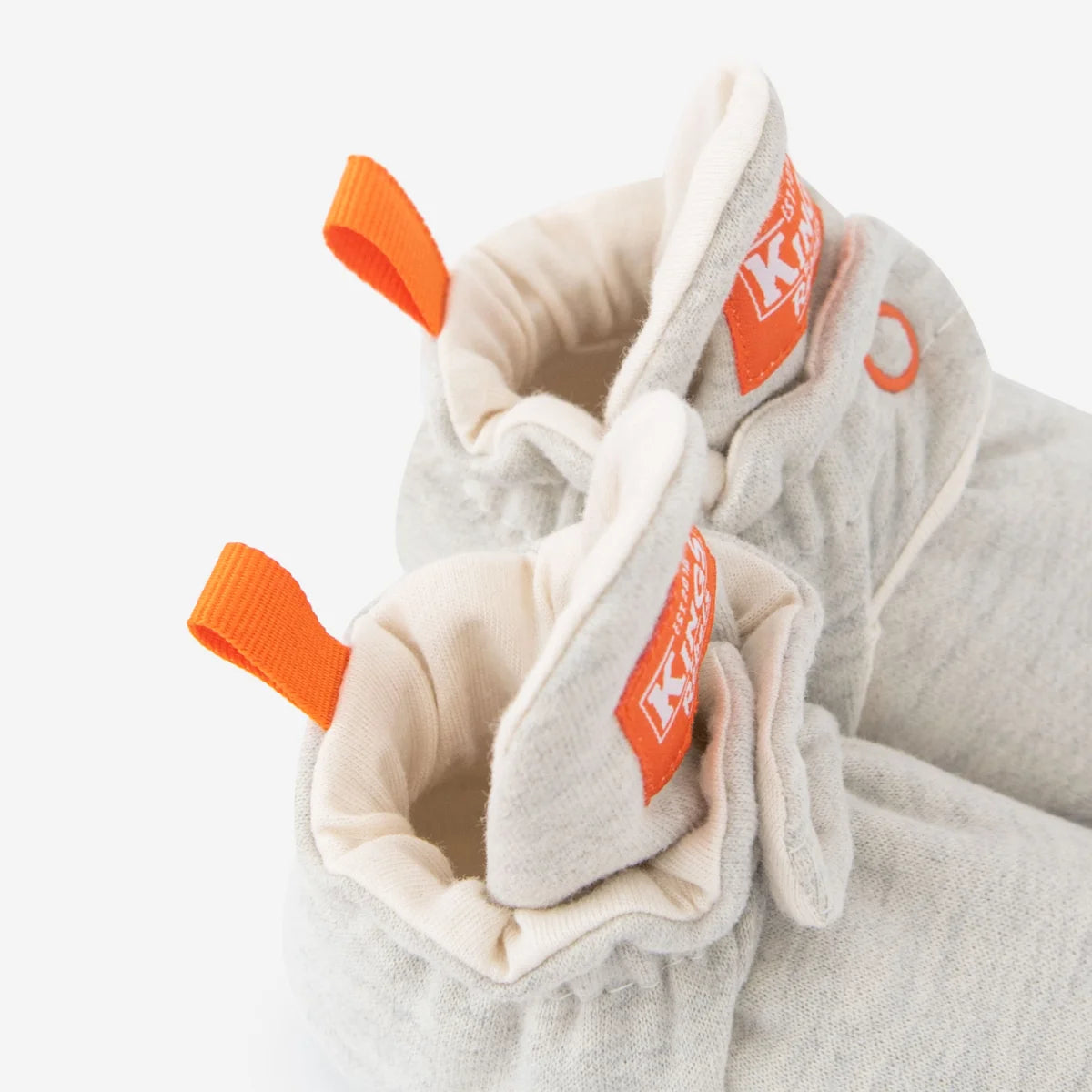 Graue strick babybooties mit orangen stofflaschen und innenfutter aus bio-baumwolle nachhaltige babykleidung schweiz