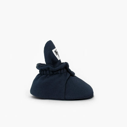Navyblaue weiche babybooties aus baumwolle mit weißem logo patch hinten ideal für nachhaltige babykleidung schweiz