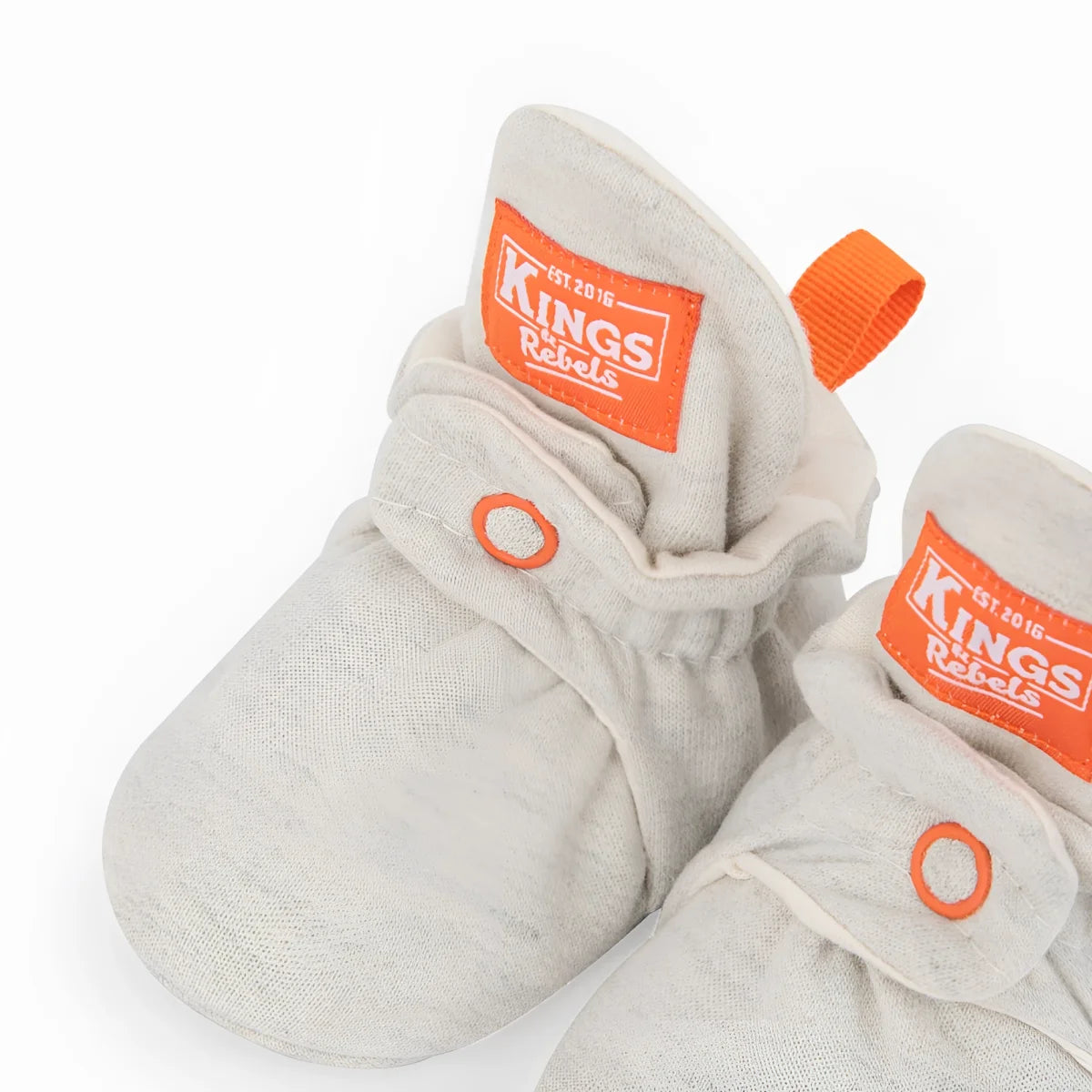 Graue baumwoll babybooties mit orangenem branding und zuglaschen nachhaltig babykleidung schweiz geschenke für neugeborene