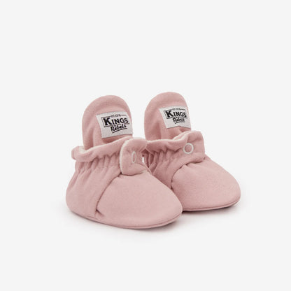 Paar rosa Babybooties mit weißen Labels an den Innenseiten der Bündchen