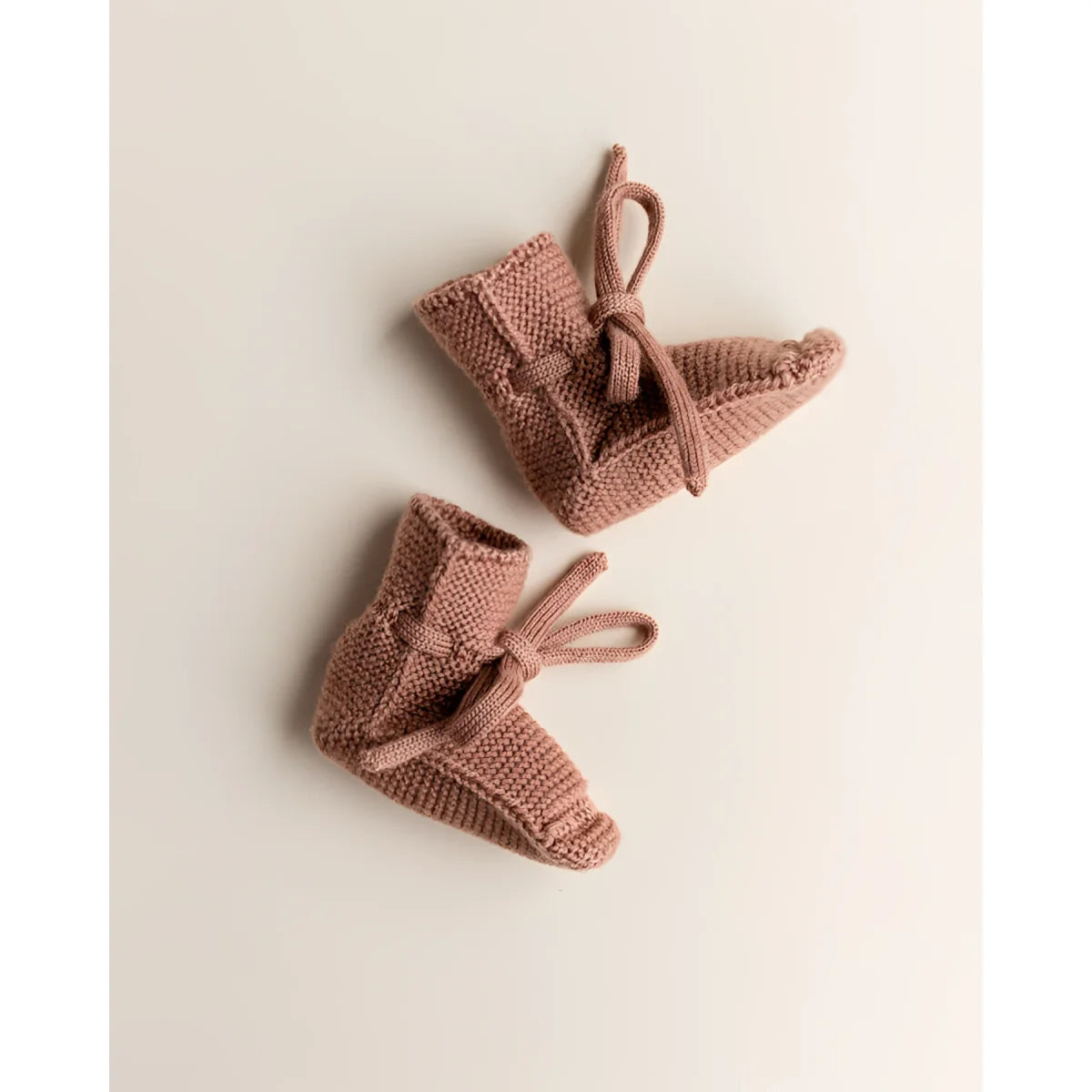 Paar rosa Strick-Babyschuhe mit Bändern, umweltfreundliche Babyartikel für ökologische Kinderbekleidung