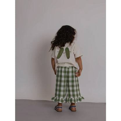 Rückseite: Kind in Boxy T-Shirt Friends Of the Garden mit Gurken-Print, Gingham-Hose