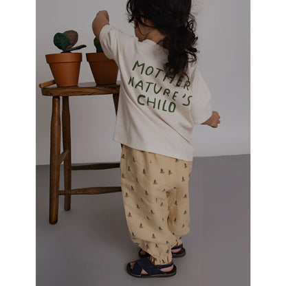 Rückseite Boxy T-Shirt Mother Natures Child: Kind in cremefarbenem Shirt mit dunkler Grün-Aufdruck